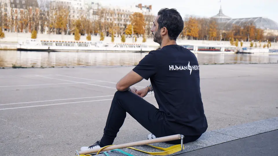 Coach sportif assis au bord de la Seine en automne, matériel d'entraînement à ses pieds