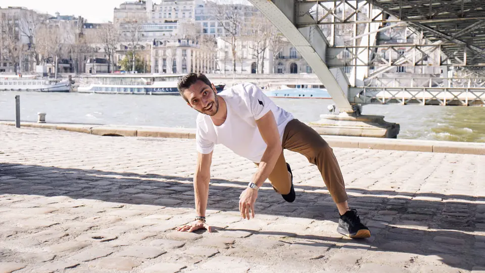 Coach sportif en mouvement au sol sous un pont, sur les pavés des quais de Seine