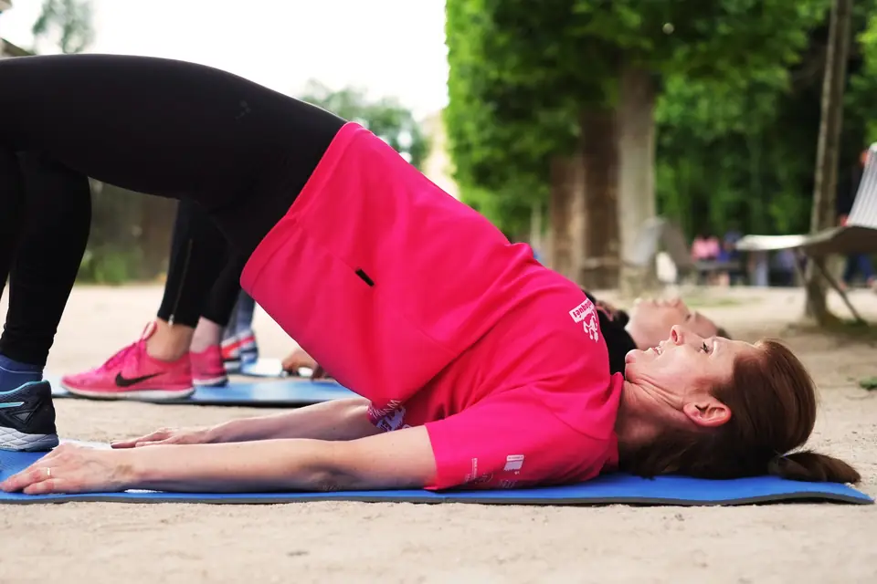 Femme en pont fessier sur un tapis, en extérieur