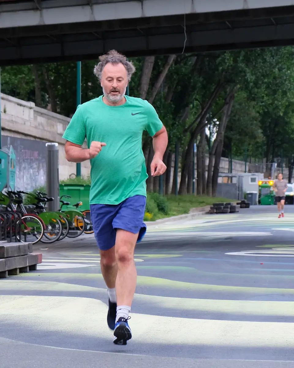 Senior aux cheveux gris courant sur les quais de Seine